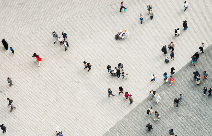 aerial view of paved urban square with pedestrians walking in the city