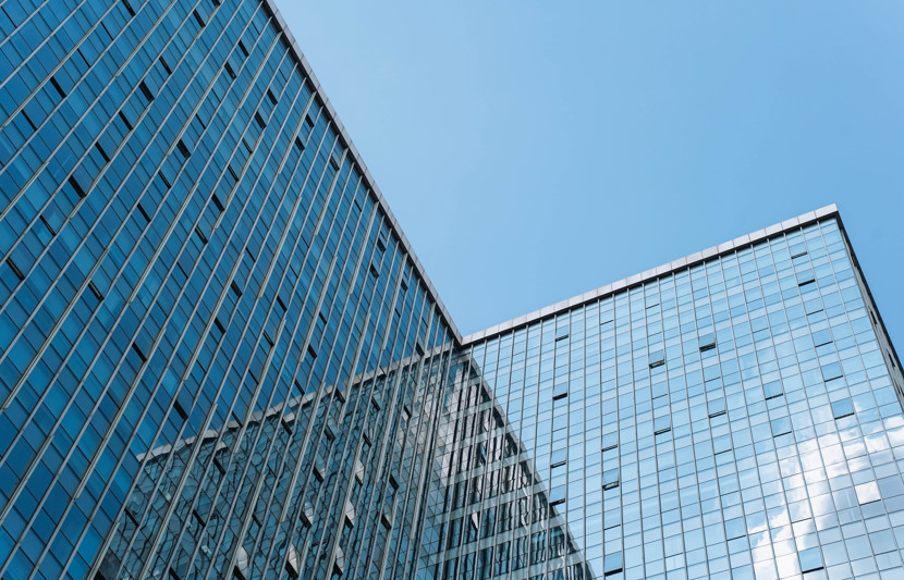 High rise property reflecting blue sky