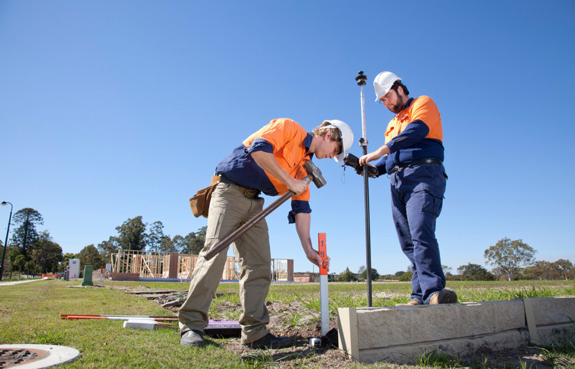 RPS surveyors use measuring equipment and hammer in a new masterplanned community. 